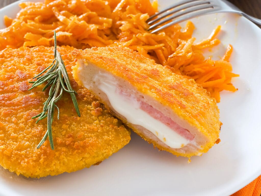 Chicken cordon bleu with grated carrots.