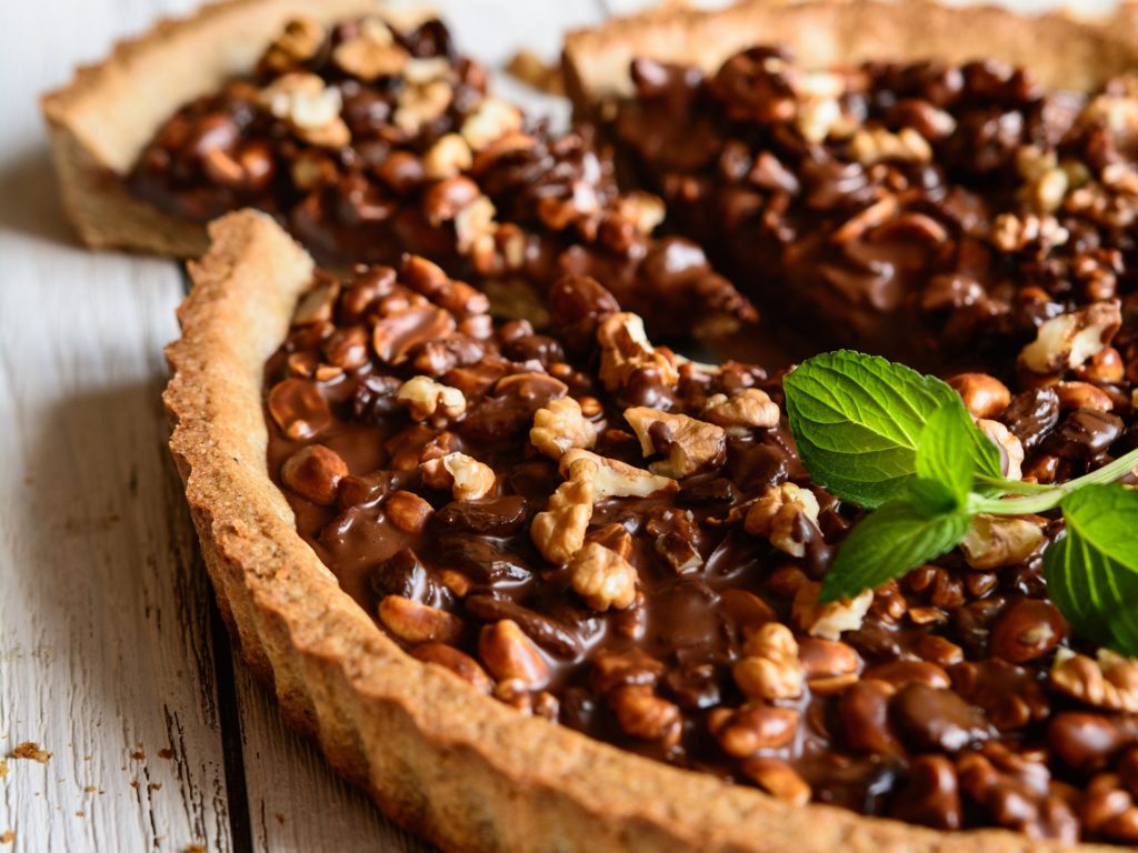 Delicious tart filled with chocolate, walnut, peanut, dried cranberry and raisins