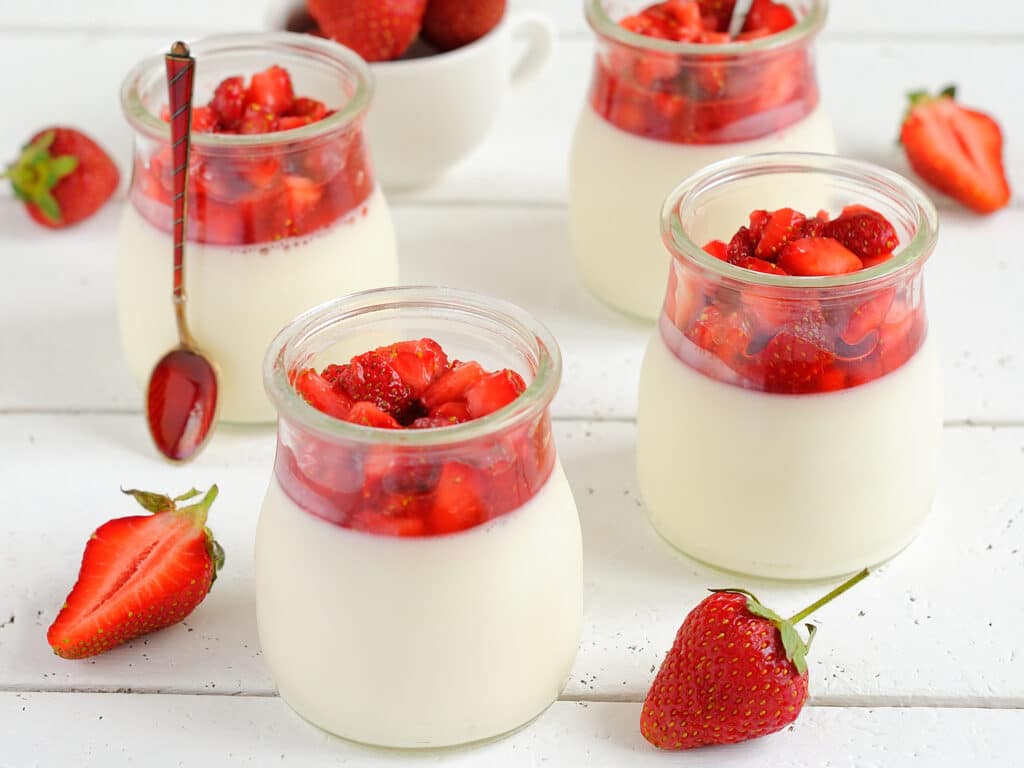 Panna cotta with strawberries on a white table