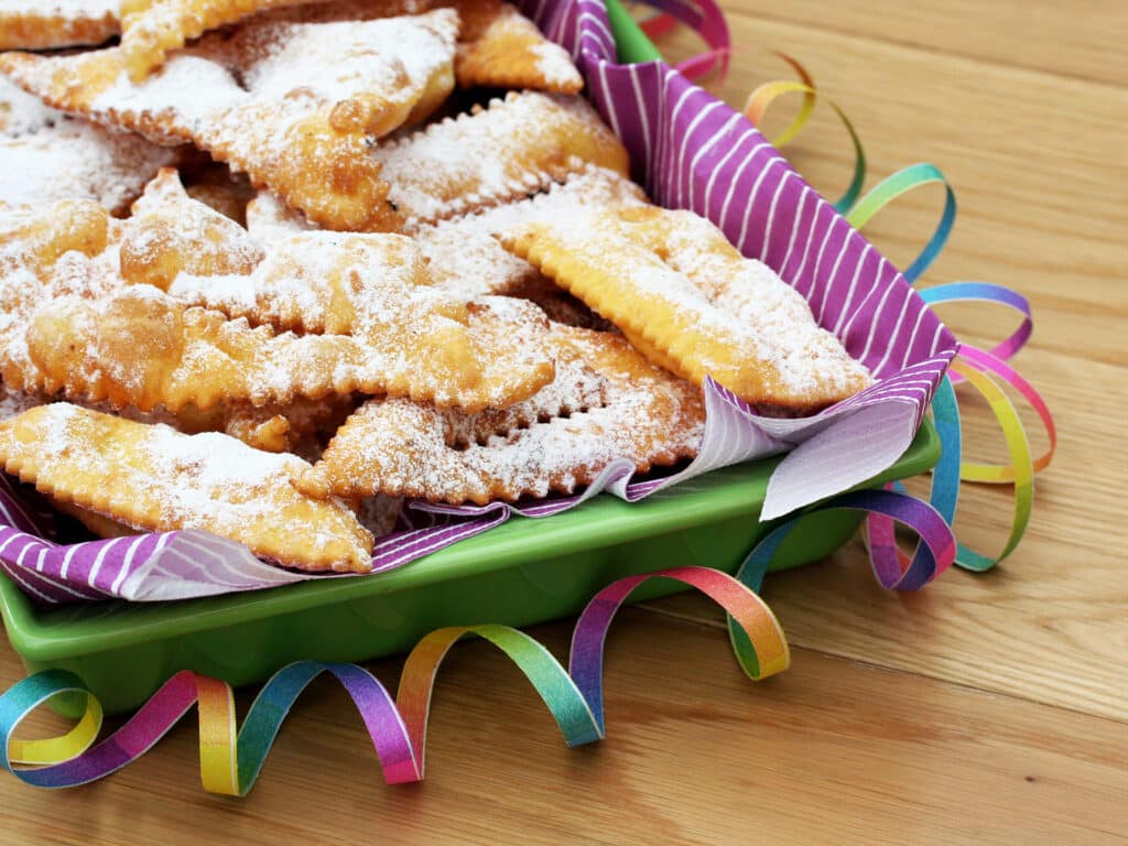 Italian carnival pastry on wooden background. Traditional Crostoli or chiacchere, bugie or cenci.