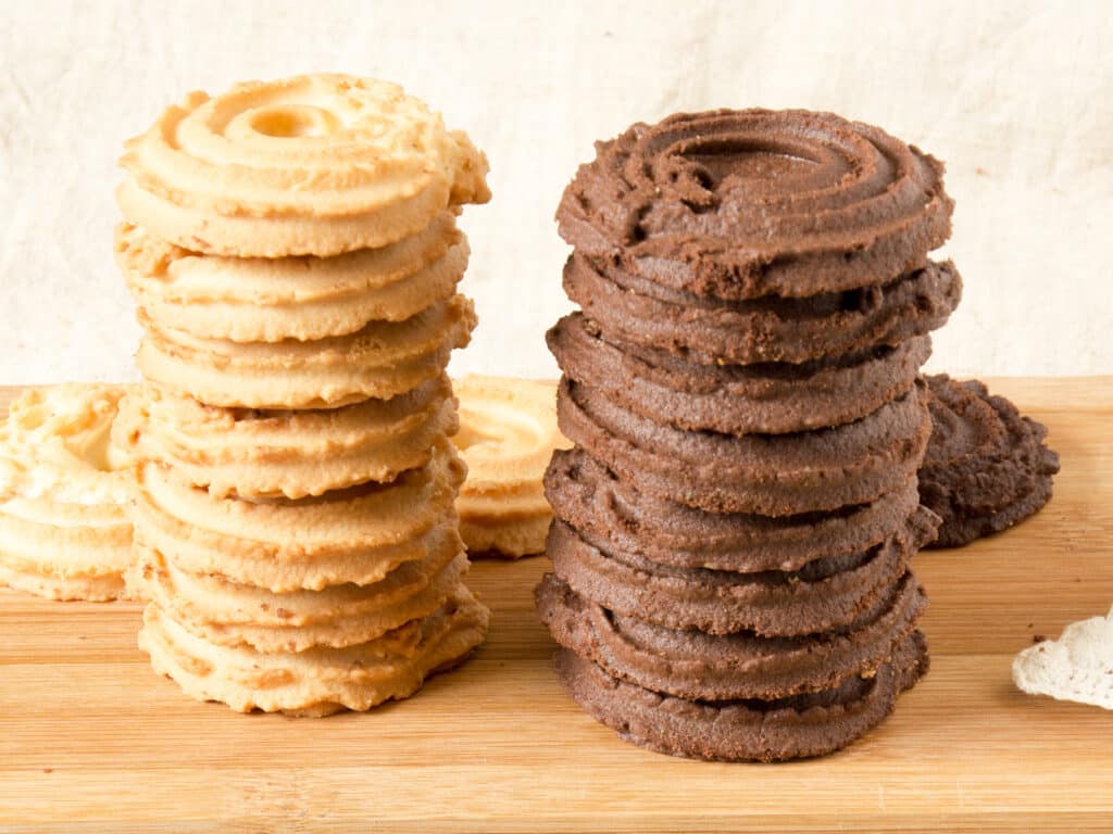 Stacked homemade vanilla and cocoa cookies on the wooden tray