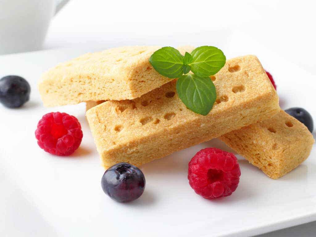 tasty shortbread fingers with fresh fruits and coffee