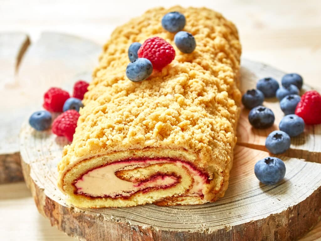bright colorful cake roll on wood with berry. Shallow dof