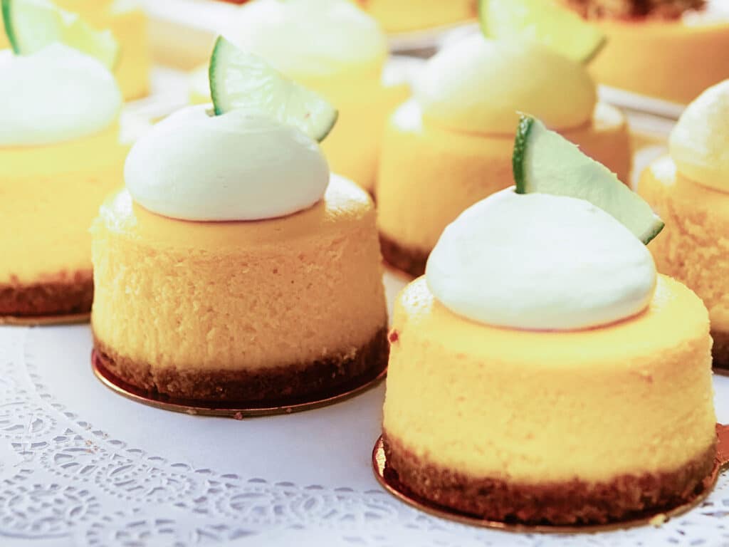 Vanilla Cheesecake pie desserts with cream and slice of a lime topping in the fridge.