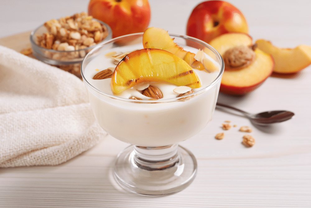 Coppette di crema, pesche e mandorle - iStock-1441416435