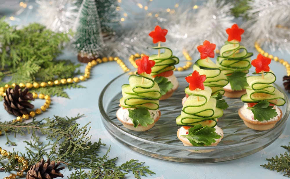 Canapes festive a forma di alberi di Natale fatti di cetrioli e stelle di pepe rosso_iStock-1285528933